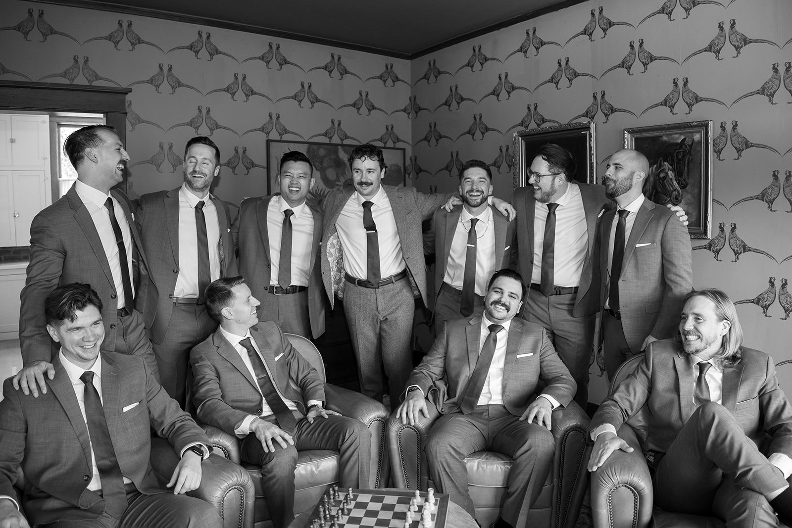 Black and white portrait of a groom and his groomsmen with chess in the den at The Swanner House in San Juan Capistrano, CA.