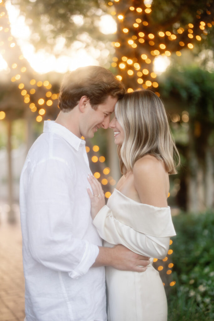 Couple posing in front of a tree with lights at El Encanto in Santa Barbara during golden hour.