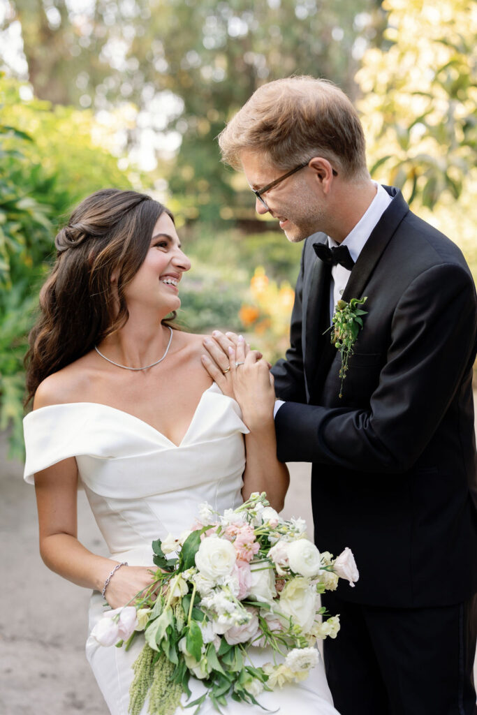 Couple smiling and holding hands while taking portraits after their McCormick Home Ranch Wedding in Camarillo, CA.