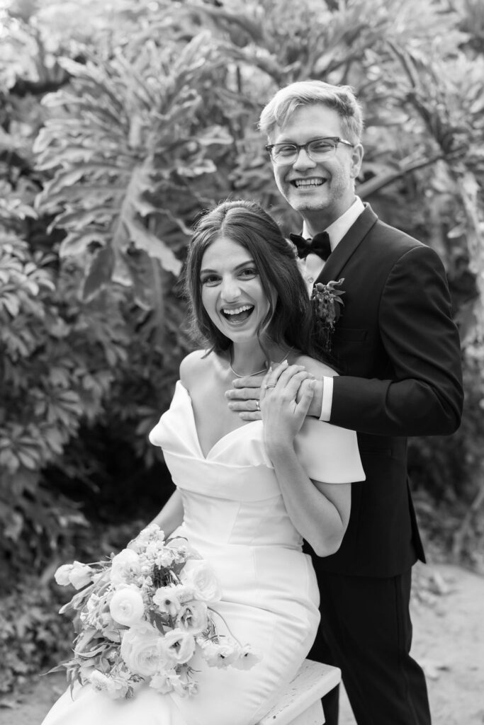 Black and white photo of a bride and groom laughing during their golden hour portraits at McCormick Home Ranch.