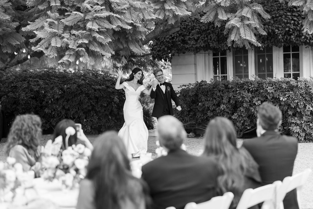 The newlyweds making their joyful reception entrance on the circular lawn at McCormick Home Ranch.