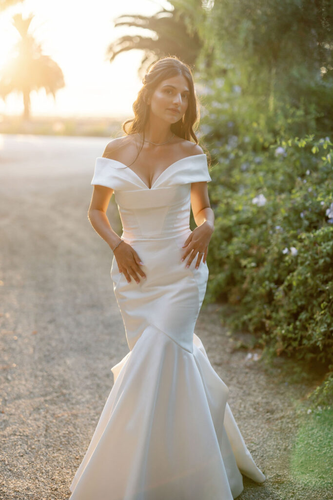 Bride standing in golden hour light at McCormick Home Ranch, wearing an off-the-shoulder gown.