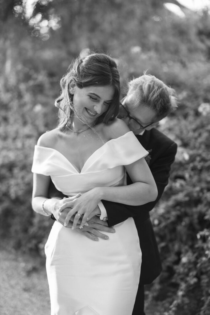 Black and white photo of the couple laughing while standing together during portraits at McCormick Home Ranch.