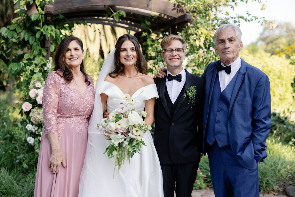 Bride and groom posing with the parent of the bride