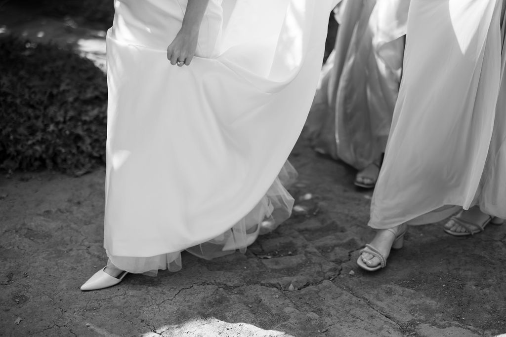 Close up shot of a bride walking with her bridesmaids following behind her.
