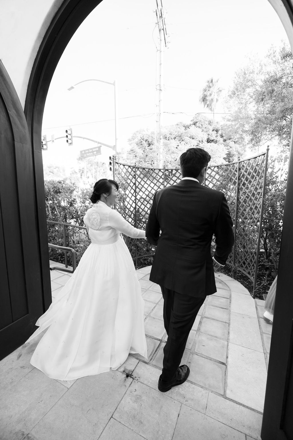 Black and white candid photo of a couple walking back together after their ceremony.