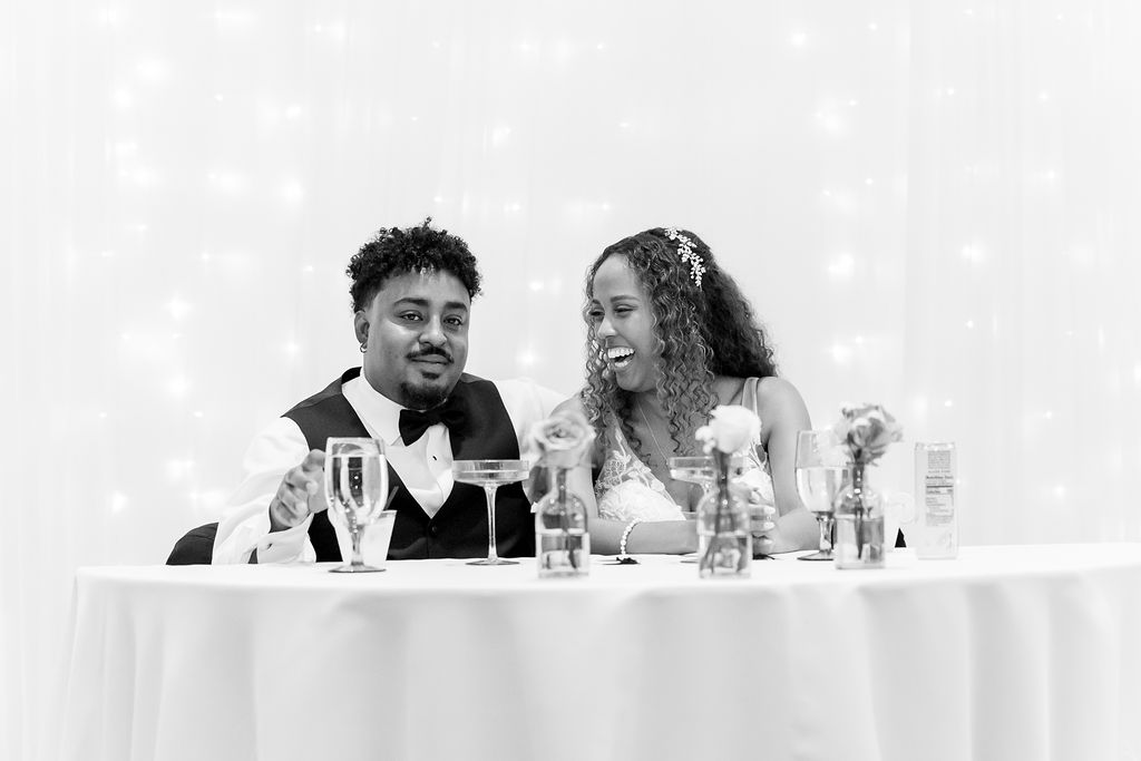 Bride and groom laughing during their La Ventura San Clemente wedding reception in the Grand Parlour.