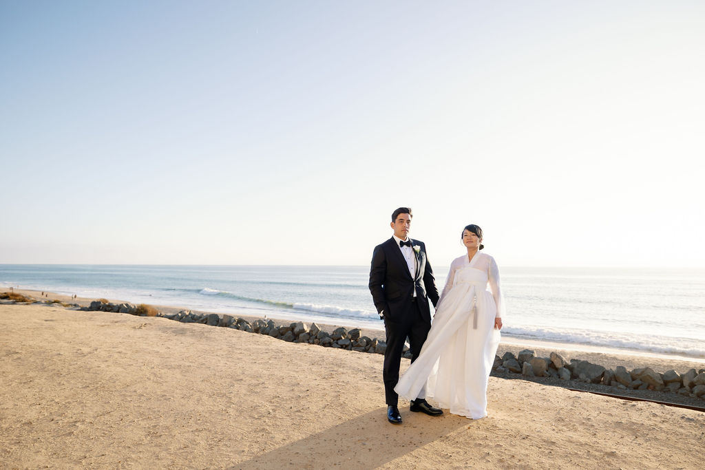 Bride and groom posing at Calafia State Beach in Southern California.