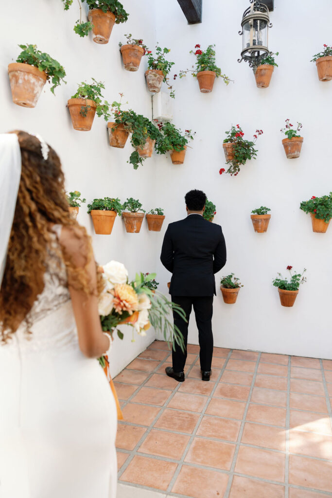 Bride and groom about to share a first look in the Spanish Potted Garden at La Ventura San Clemente.