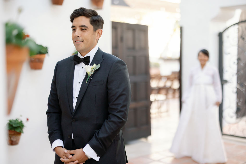 Groom waiting to share a first look with the bride in the Spanish Potted Garden at La Ventura San Clemente.