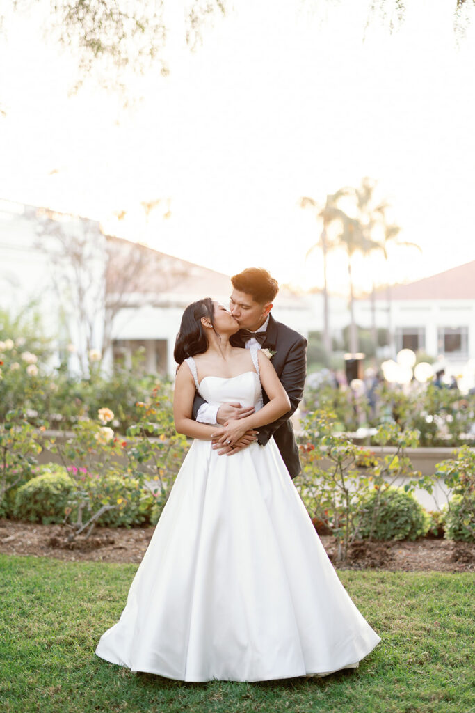 Bride and groom kissing during golden hour portraits at Nixon Library in Yorba Linda.