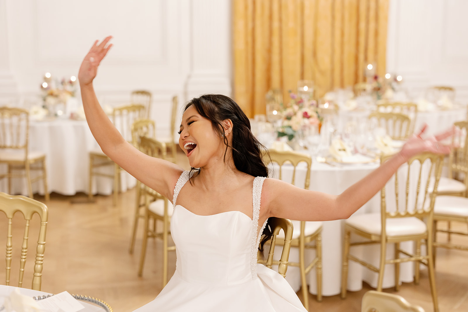 Bride smiling listening to the groom play guitar.