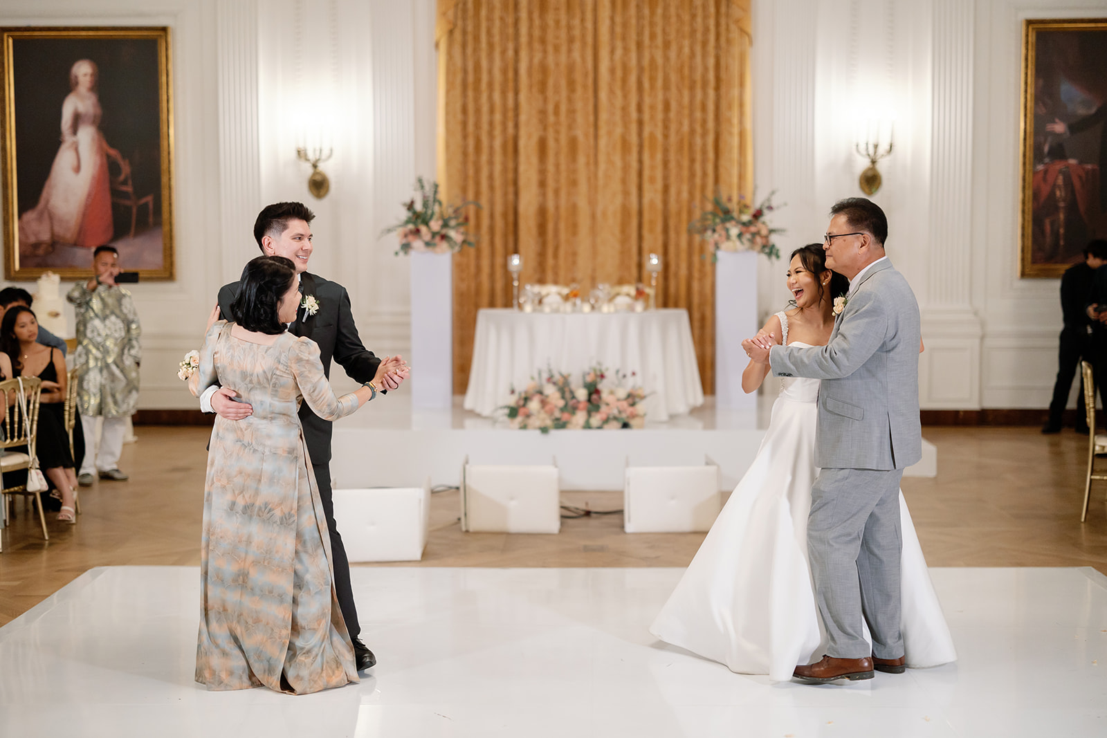 Bride dances with her father while the groom dances with his mother during the Nixon Library Yorba Linda wedding reception.