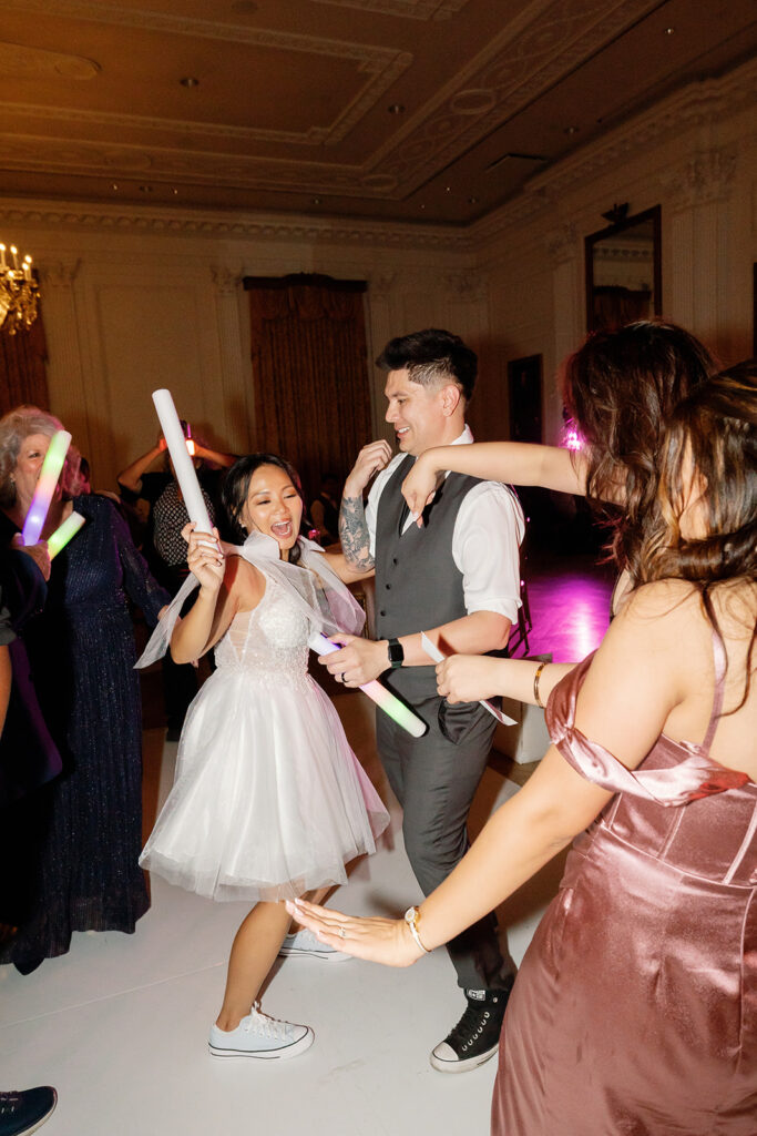 Bride and groom dancing with glow sticks during their reception.