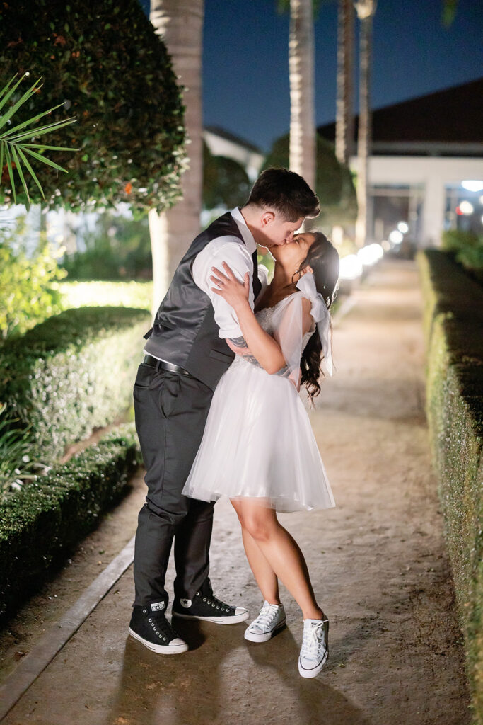 Couple kisses during nighttime portraits along the gardens at the Nixon Library in Yorba Linda.