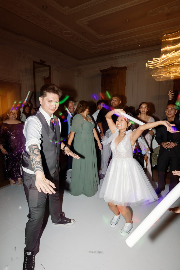 Bride and groom dancing with glow sticks during their reception.