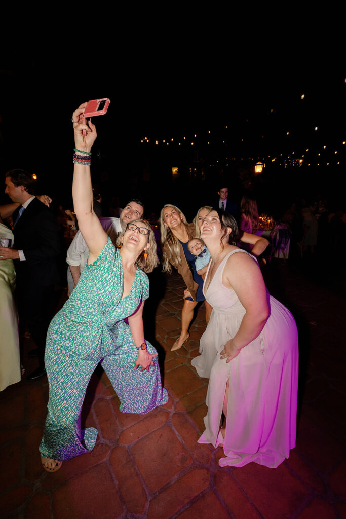 Group of wedding guests taking a selfie together.