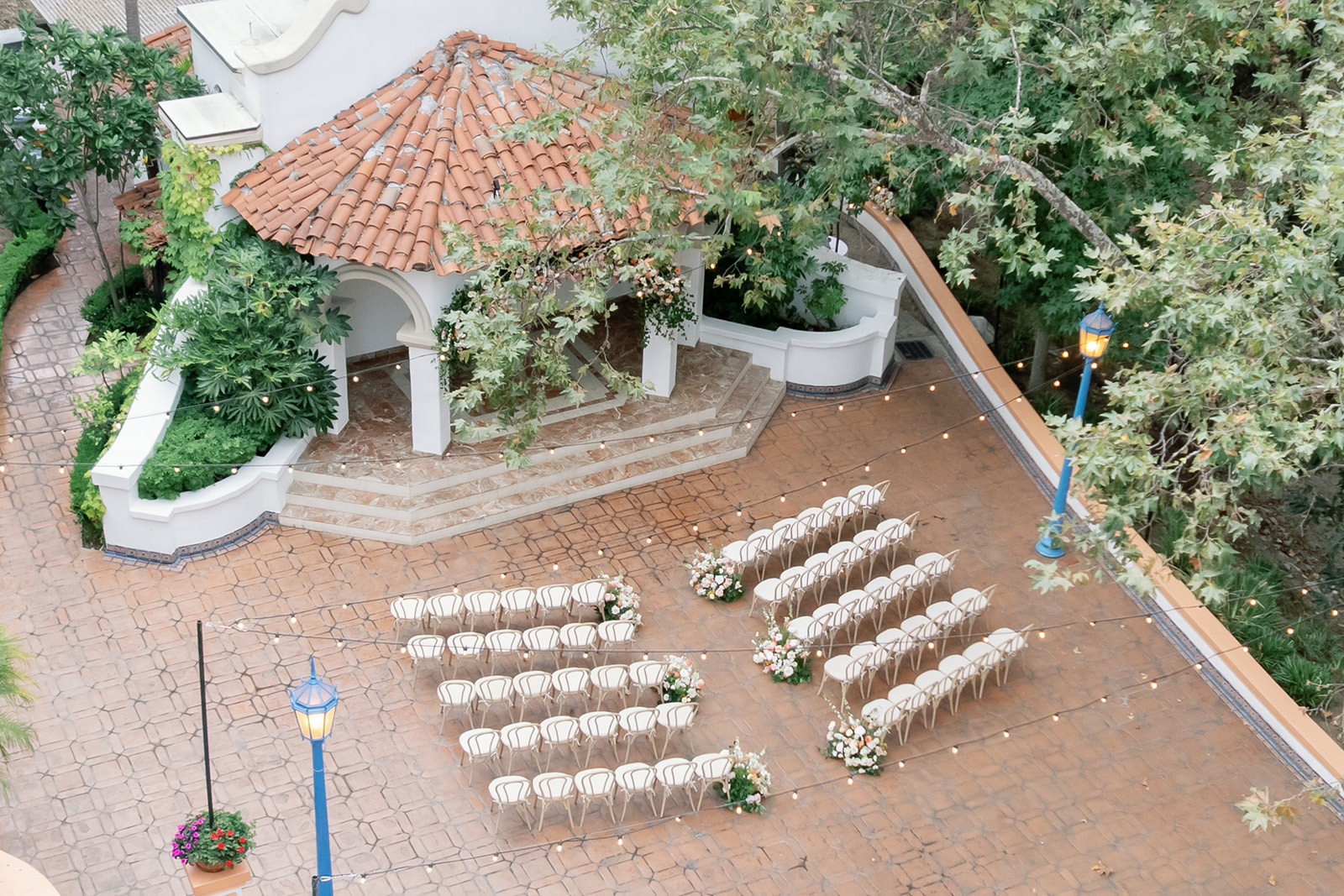 Aerial view of El Teatro ceremony setup at Rancho Las Lomas surrounded by trees and string lights.