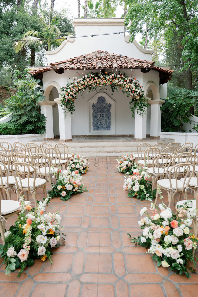El Teatro ceremony space at Rancho Las Lomas with floral-lined aisle and marble stage.
