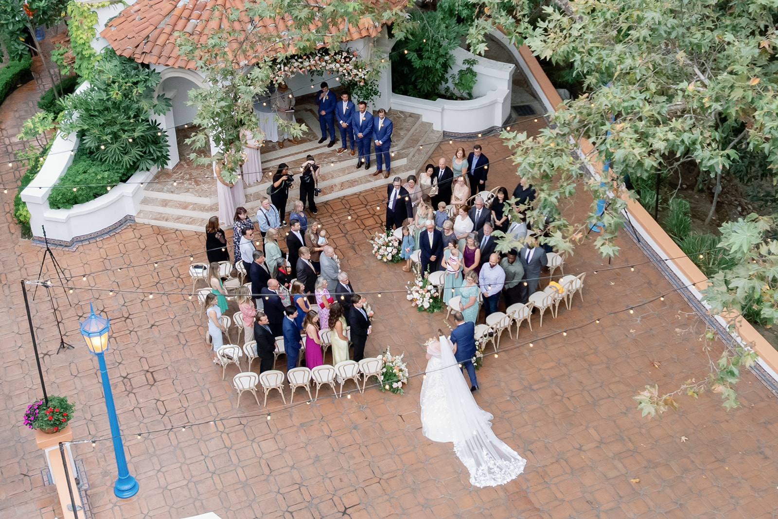 Overhead view of guests gathered for the El Teatro ceremony at Rancho Las Lomas as the bride walks down the aisle with her father.