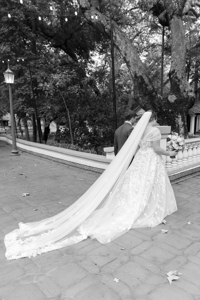 Black and white photo of a bride and groom walking away from the ceremony as husband and wife after their ceremony.