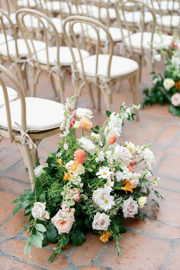 Floral arrangements lining the aisle at El Teatro for a Rancho Las Lomas wedding.