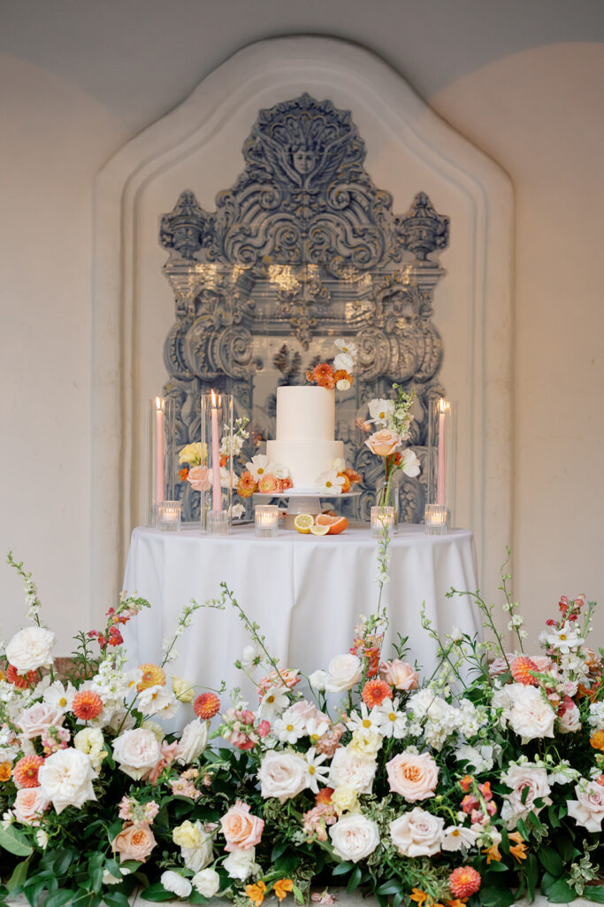 Wedding cake table decorated with citrus flowers and greenery at Rancho Las Lomas reception in El Teatro.
