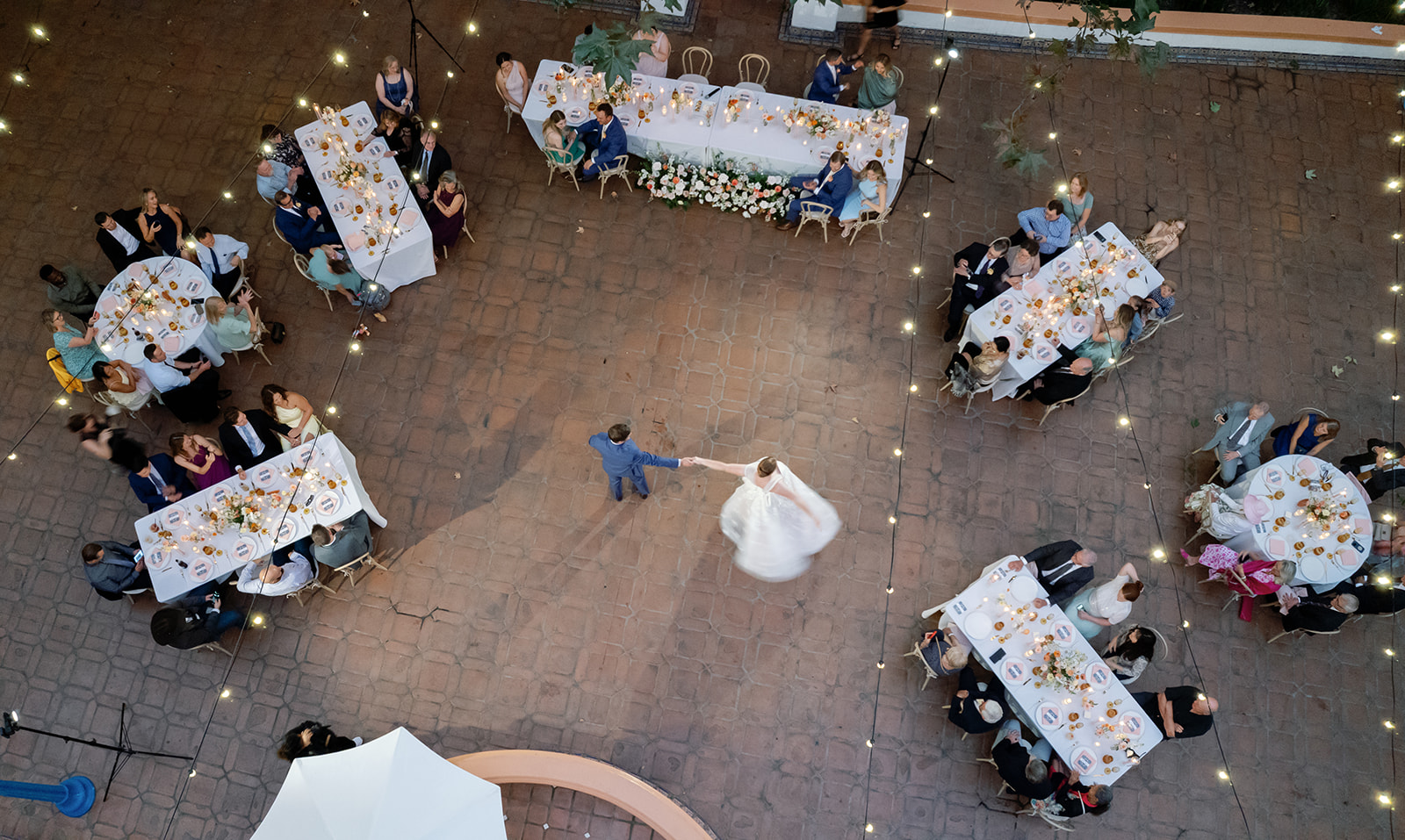 Overhead view of the couple’s first dance surrounded by guests and long reception tables at Rancho Las Lomas.