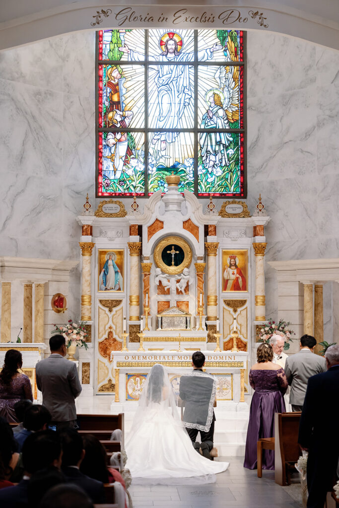 Wide view of the altar and stained glass during a wedding ceremony at St. Martin de Porres Church in Yorba Linda.