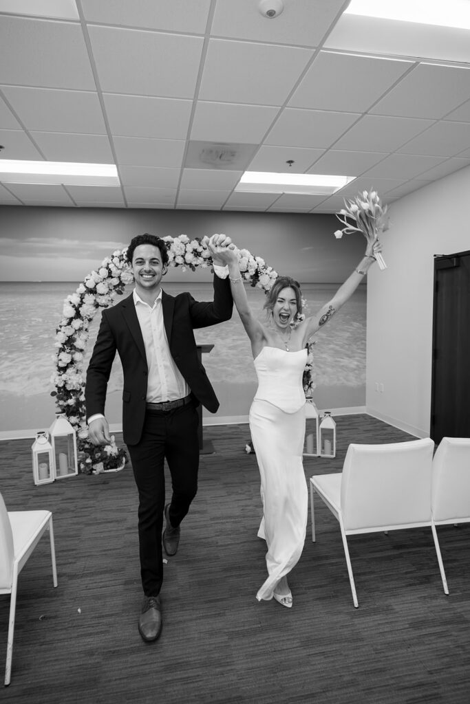 Bride and groom walking down aisle celebrating after Laguna Hills Civic Center elopement ceremony.
