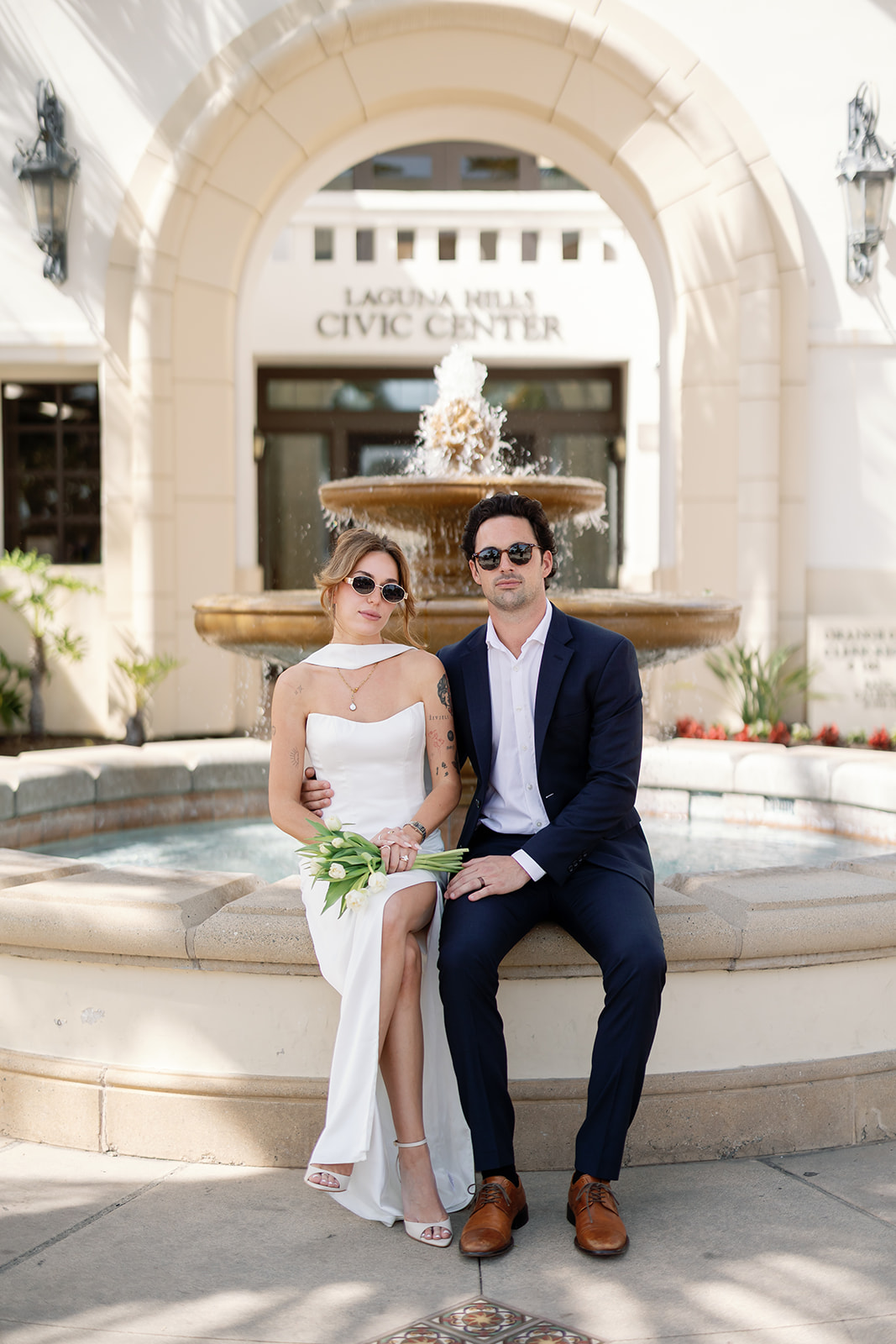 Bride and groom posing outside of Laguna Hills Civic Center after their elopement.