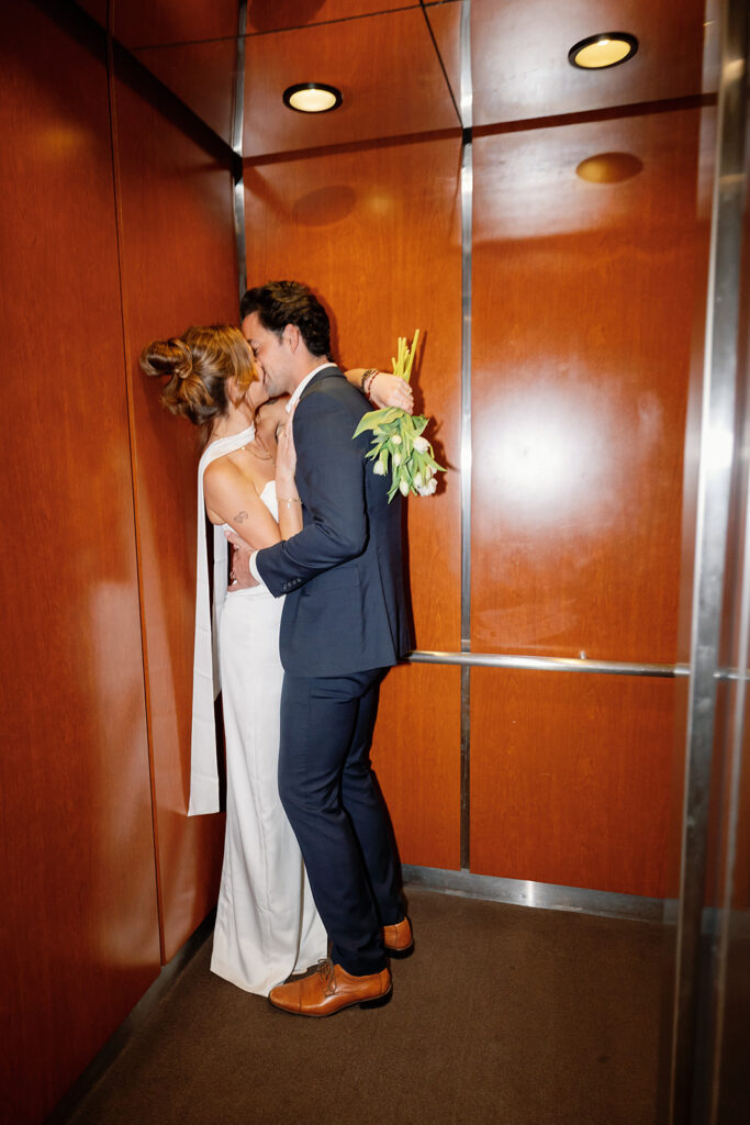 Bride and groom kissing inside of an elevator at Laguna Hills Civic Center in Orange County, CA.