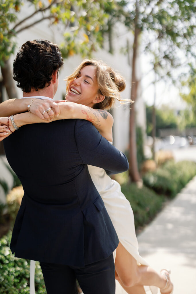 Close up photo of a bride lifting up his bride in a playful way for their Laguna Hills Civic Center elopement photos outdoors.
