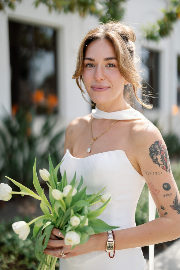 Close up portrait of a bride holding a bouquet outside of Laguna Hills Civic Center after elopement ceremony.