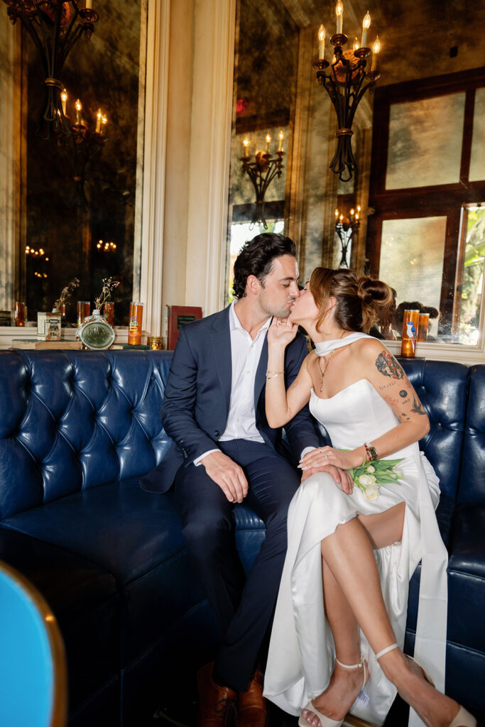 Bride and groom kissing on blue leather booth at Habana in Irvine Spectrum after Laguna Hills Courthouse elopement.