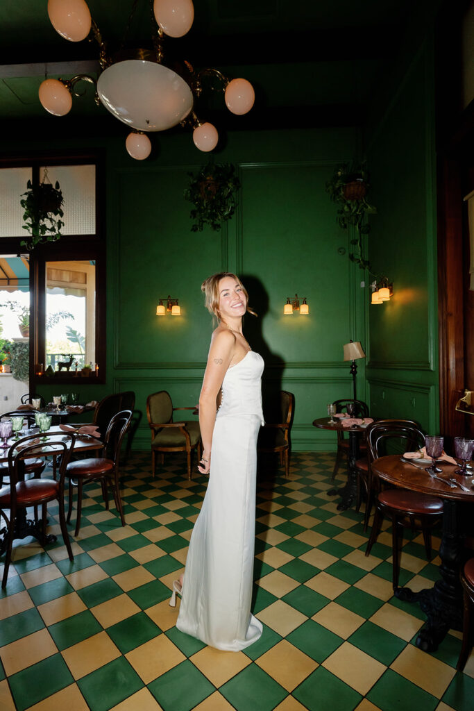 Bride posing in green tiled dining room with direct flash at Habana in Irvine Spectrum after courthouse elopement.