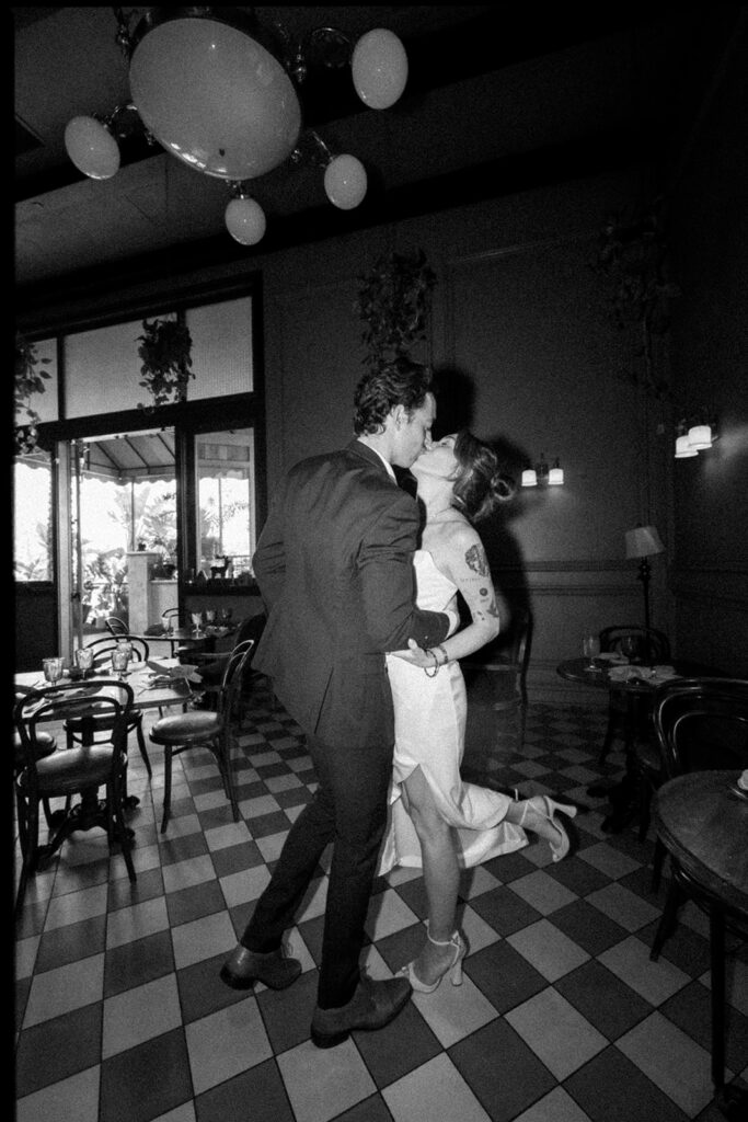 Black and white flash portrait of a bride and groom kissing while at Habana Irvine Spectrum after elopement.