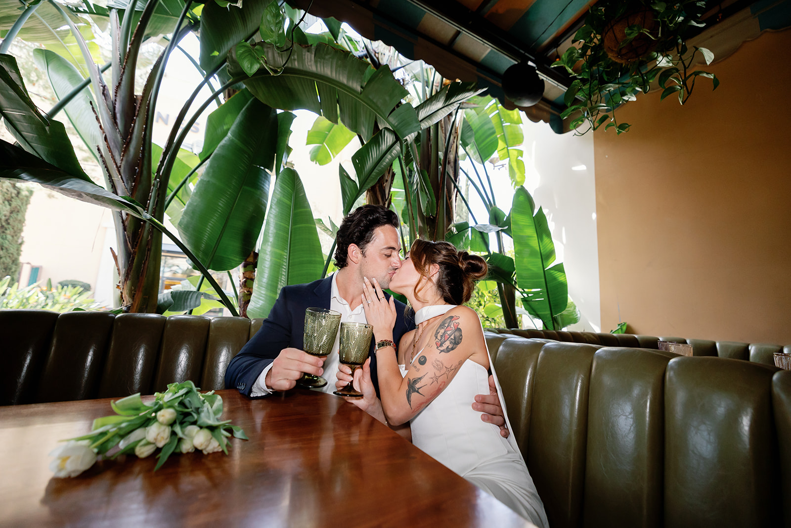 Bride and groom kissing at a booth at Habana in Irvine Spectrum.