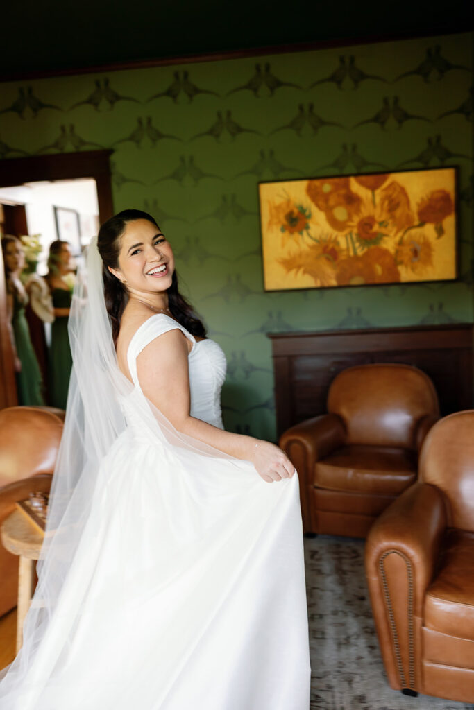 Bride smiling in the den with leather chairs at Swanner House wedding.