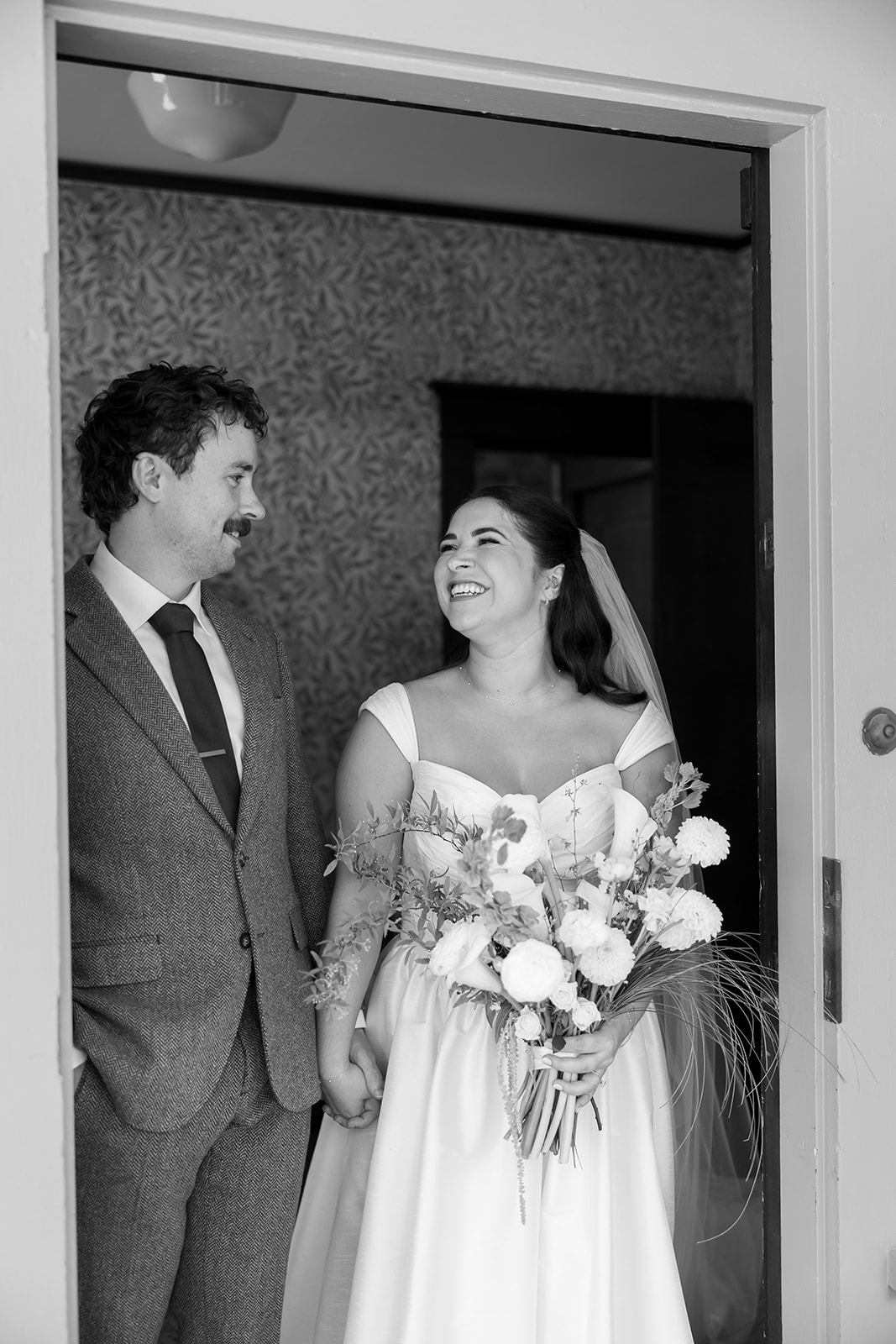 Bride and groom holding hands and smiling after their first look at Swanner House wedding.