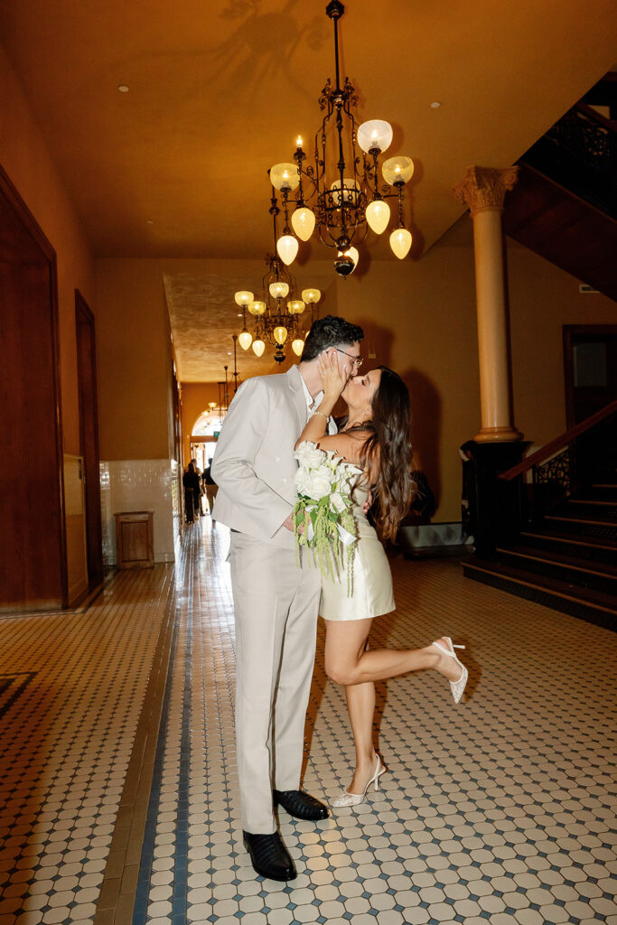 Bride and groom kissing in the hallways at Old Orange County Courthouse in Santa Ana, California.