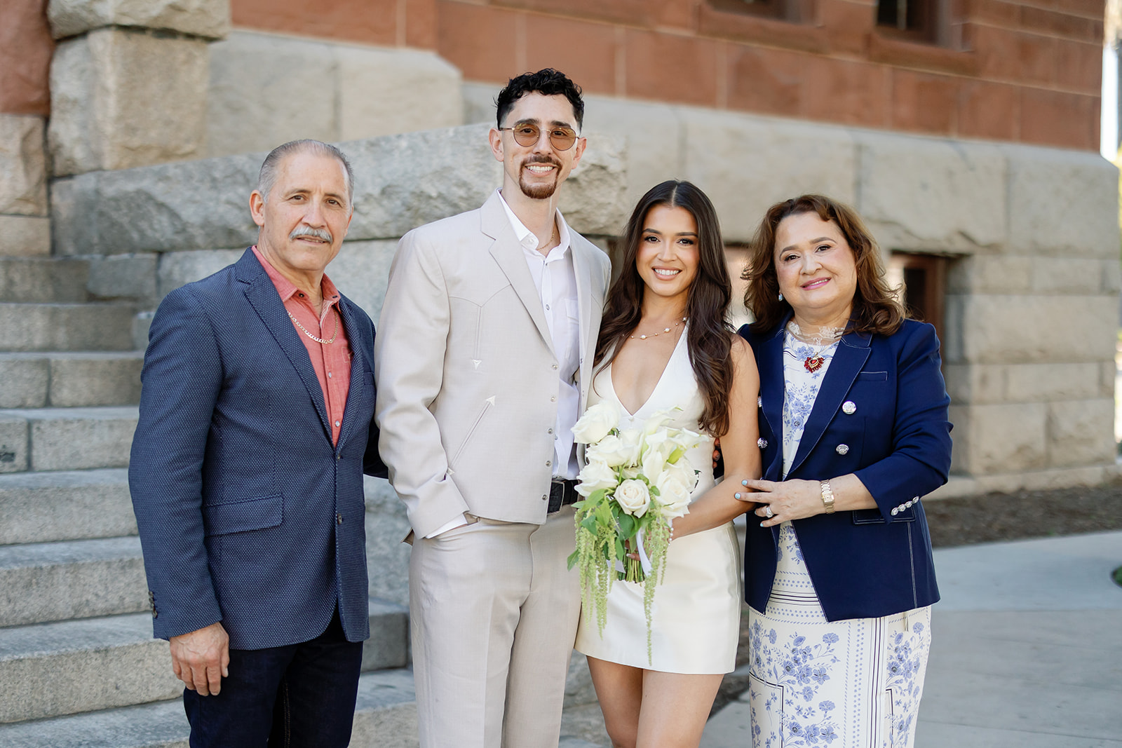 Bride and groom posing with family members outside of Old Orange County Courthouse in Santa Ana, California.
