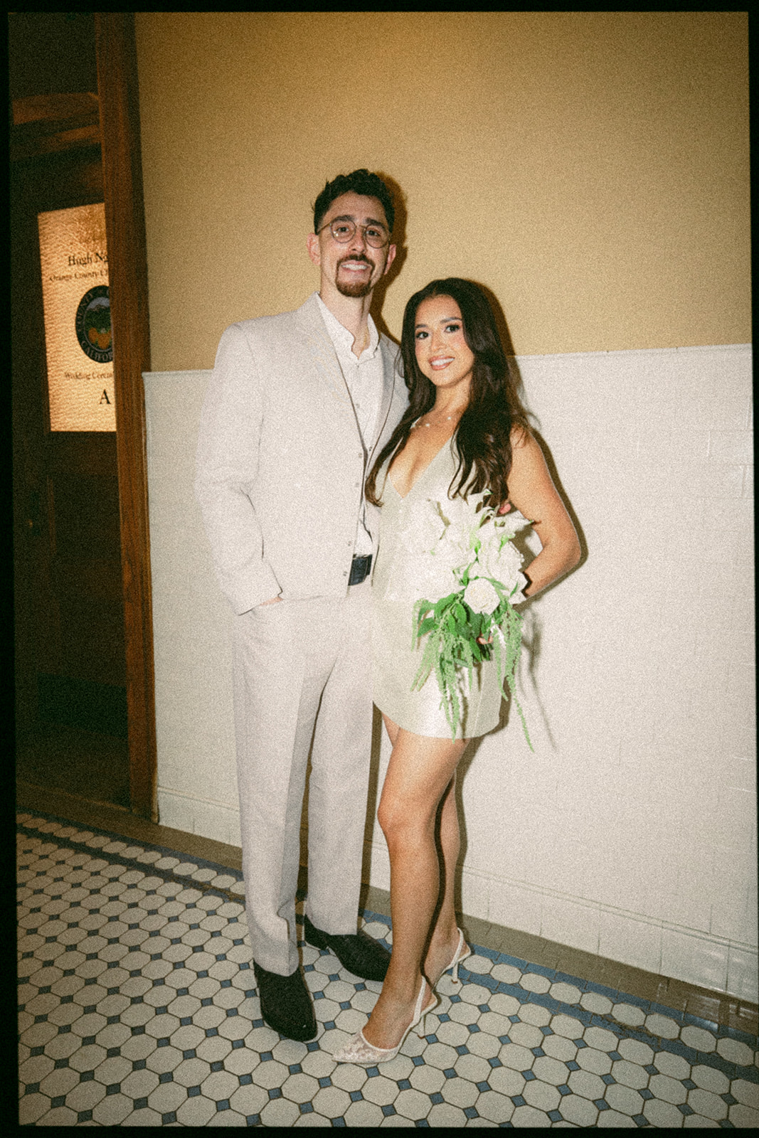 Bride and groom 35mm film portrait with direct flash inside Old Orange County Courthouse in Santa Ana.
