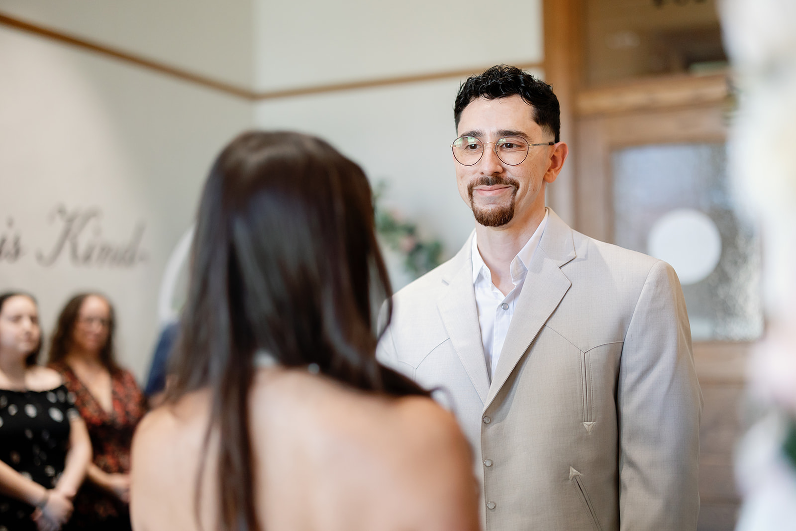 Groom smiling at his bride during their intimate courthouse wedding ceremony.