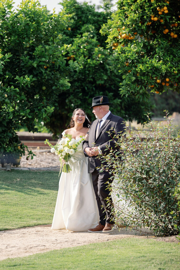 Bride walking down aisle with her father during Swanner House wedding ceremony.