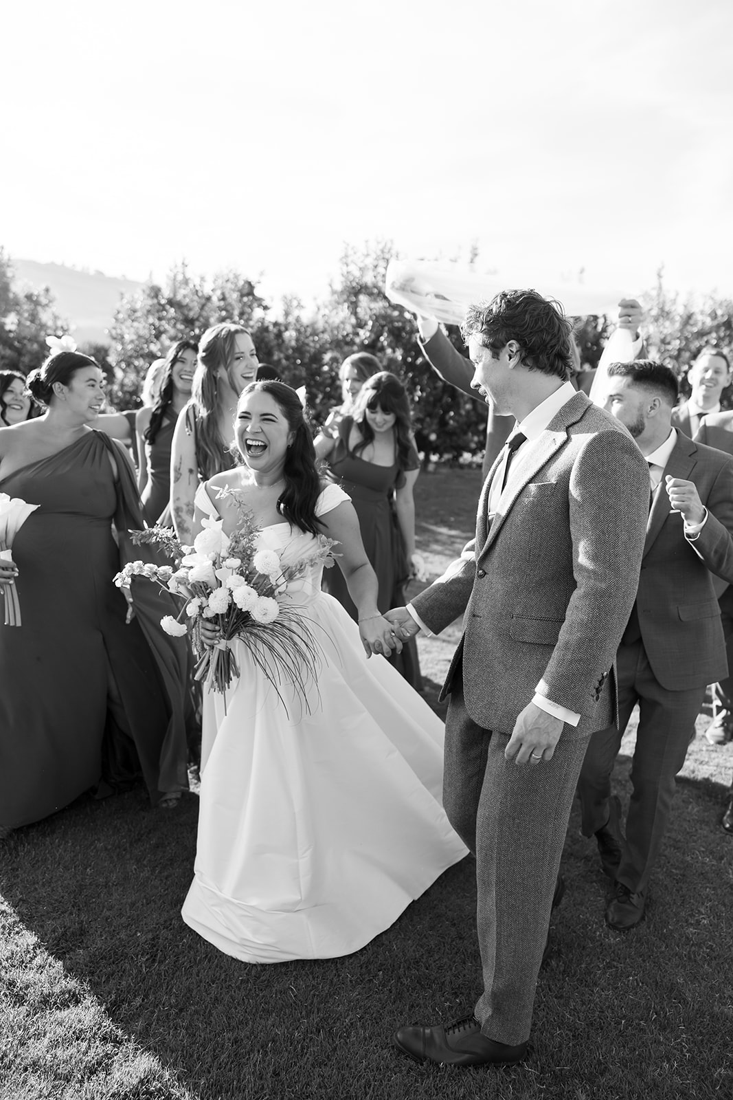 Bride and groom walking with wedding party after ceremony at Swanner House wedding in San Juan Capistrano.