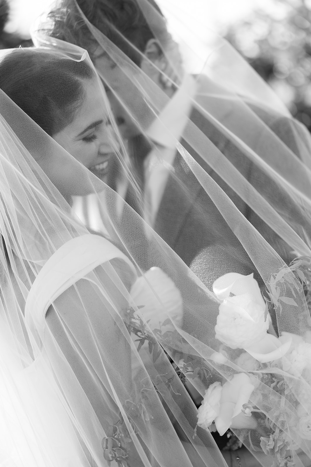 Close up of bride and groom under veil during portraits.