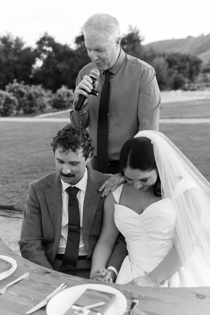 Bride and groom praying together during reception at a Swanner House wedding in San Juan Capistrano.
