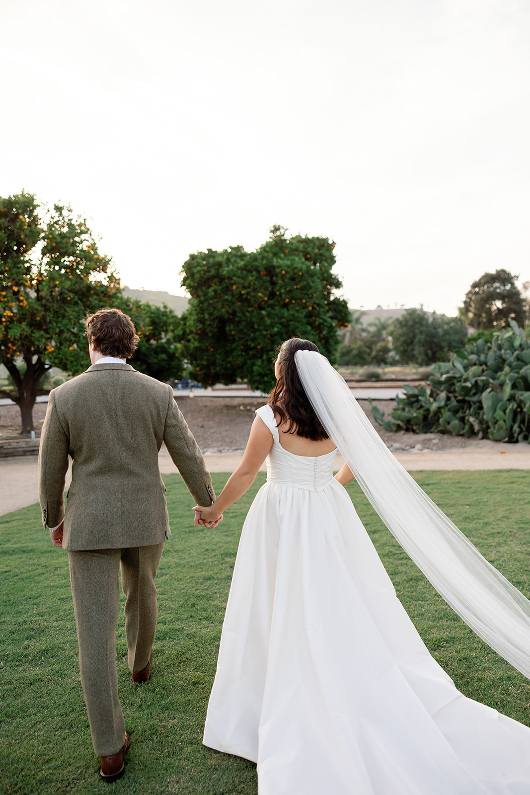 Bride and groom walking the grounds at The Swanner House in San Juan Capistrano.