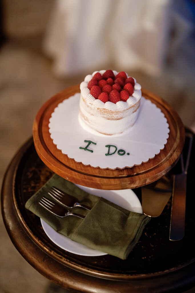 Small wedding cake with raspberries and “I Do.” detail at a Swanner House wedding in San Juan Capistrano.